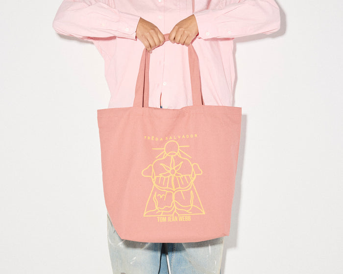 Limited edition illustrated tote bag by Freda Salvador in dusty rose with artistic design, perfect for carrying marketing materials.