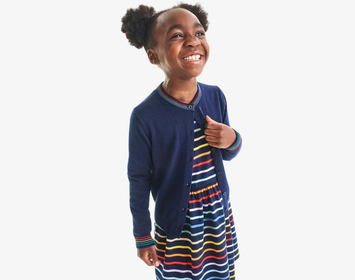 Child wearing Primary Long Sleeve Pocket Dress - Rainbow Stripe - Navy / Rainbow Stripe. Available at www.tenlittle.com