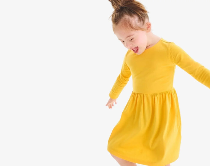 Child wearing Primary Long Sleeve Pocket Dress - Sunflower. Available at www.tenlittle.com