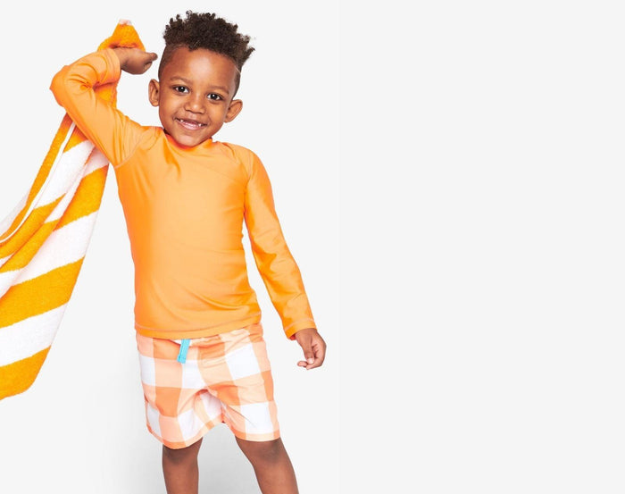 Child wearing Primary Long Sleeve Rash Guard - 2 Pack in Cantaloupe - Blueberry / Cantaloupe. Available at www.tenlittle.com