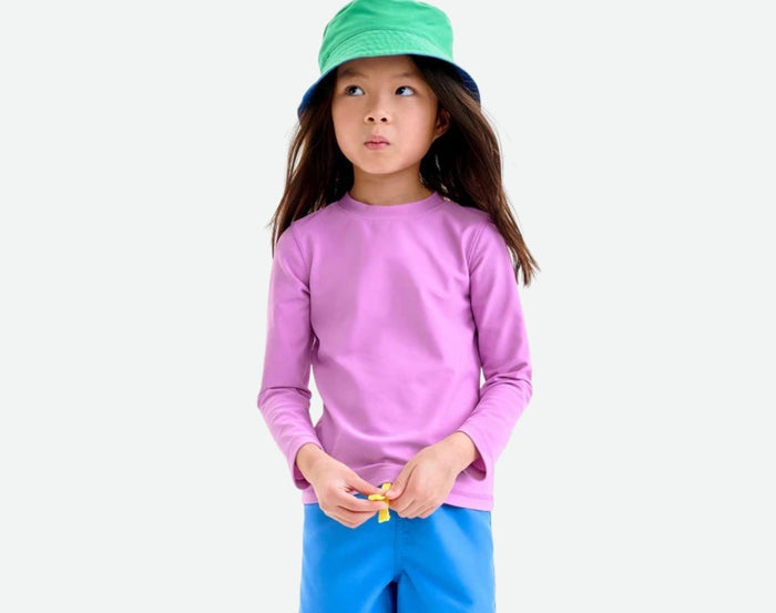 Child wearing Primary Long Sleeve Rash Guard in Lilac - 2 Pack - Bright Azalea / Lilac. Available at www.tenlittle.com
