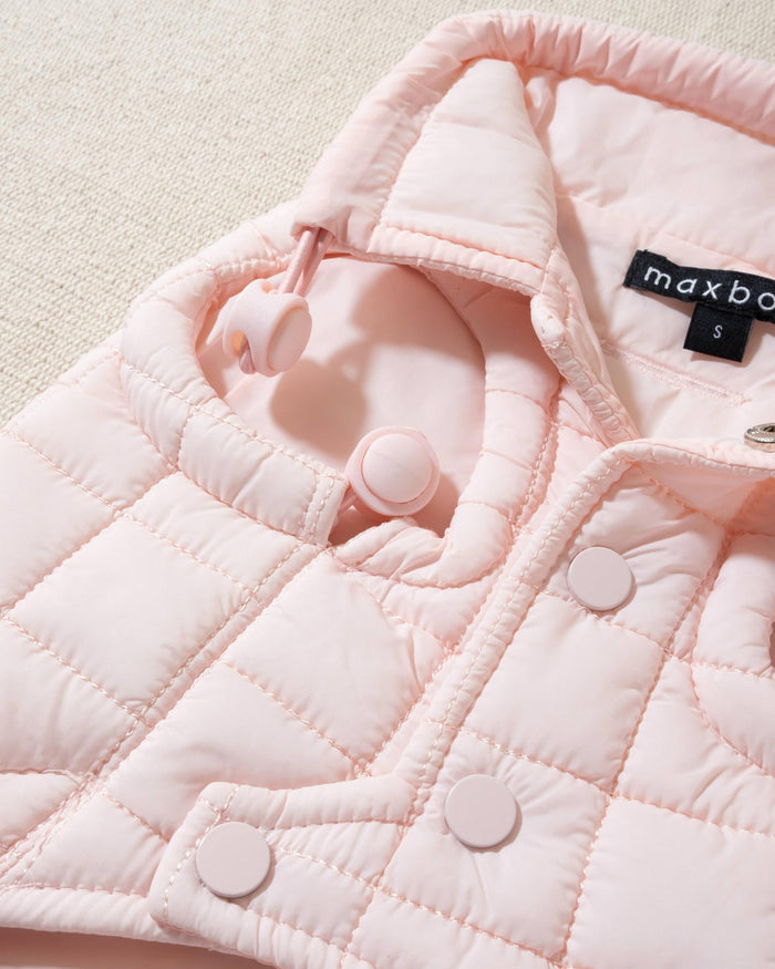 perfect on its own or layered with a cute sweater. This quilted, stylish jacket is fully adjustable, with coordinating light pink cords on the hem, neck, and arm openings. Jacket can be worn over harness, with a small opening for leash attachment on the back. Asymmetrical buttons also make for more secure wear, for even the most portly of pups!. Frenchie pink jacket.