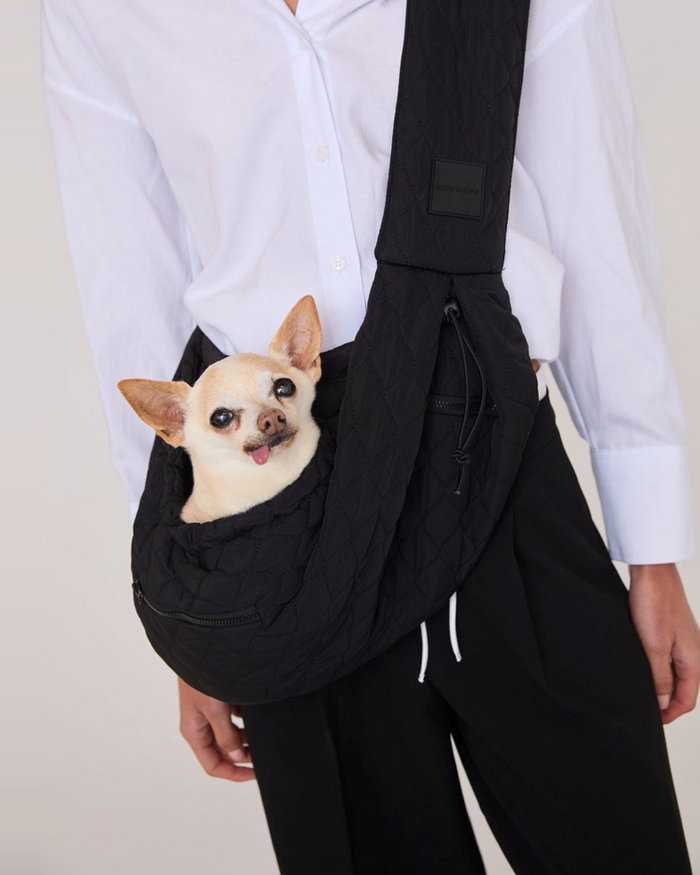 Black packable dog sling with safety latch, adjustable drawstrings and storage pockets for small dogs up to 10 pounds