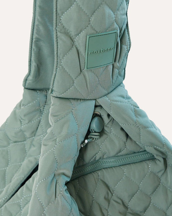 Sage green packable dog sling with safety latch, adjustable drawstrings and storage pockets for small dogs up to 10 pounds