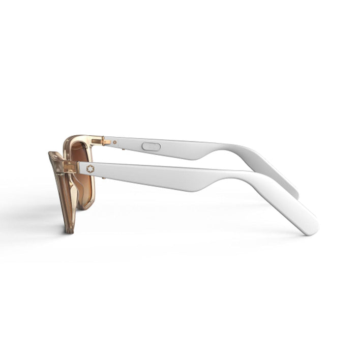 Side view of Lucyd Millennia women's eyewear with transparent beige frames, thick white temples, brown gradient lenses, small button, and metallic accent by the hinge, displayed on a plain white background.