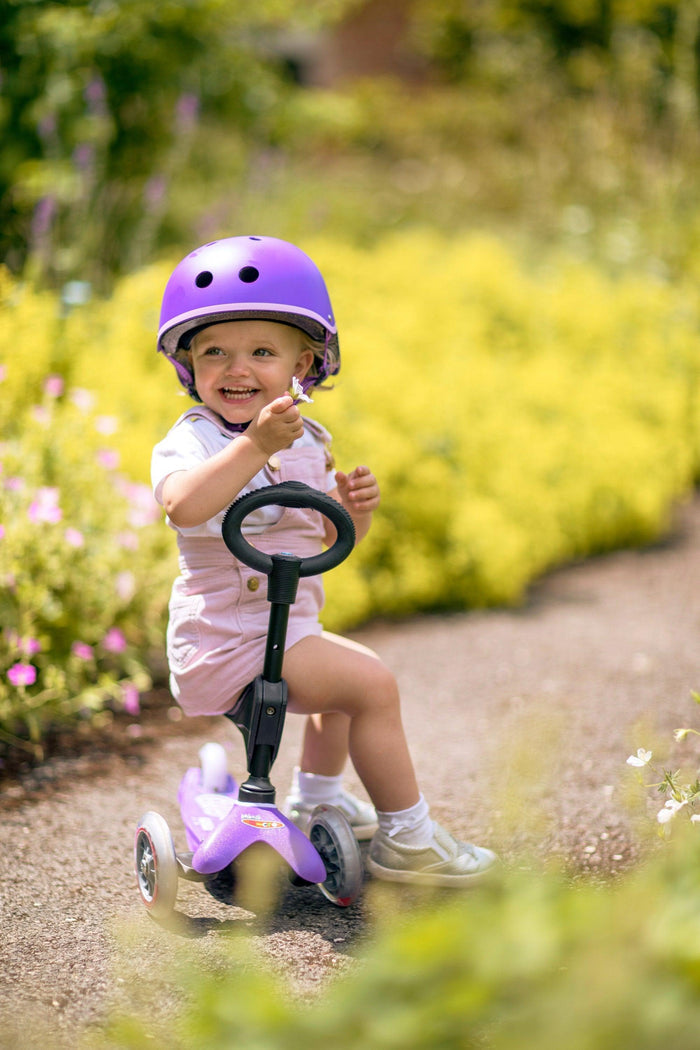 Child sitting on Micro Kickboard Mini 3in1 Deluxe Scooter. Available at www.tenlittle.com