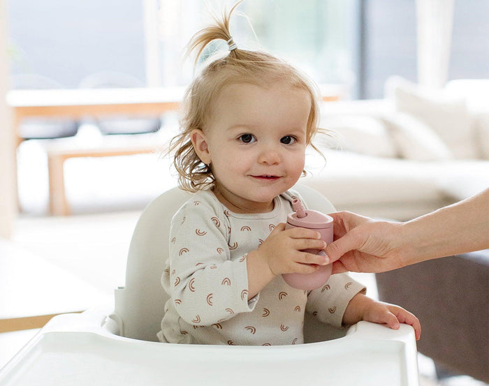 Baby Holding Ezpz Mini Cup & Straw in Blush - Available at www.tenlittle.com
