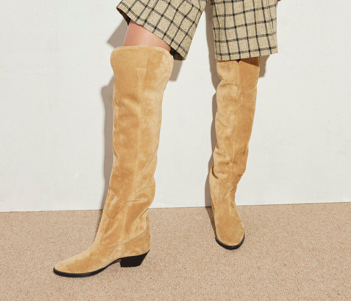 FREDA SALVADOR Molly Western knee-high boot in hazel leather with a pointed toe and chunky heel, styled with denim jeans.