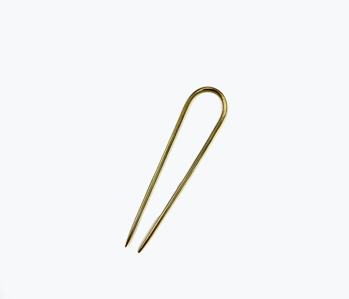 NATALIE BORTON brass French pin accessory with intricate design, displayed on a neutral background.