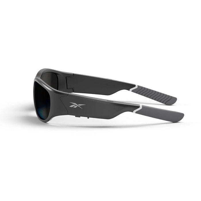 The Reebok Nitrous sunglasses feature a black wraparound design with thick frames, polarized lenses, and the Reebok logo on the side. Gray textured grips at the arm ends offer a secure fit.