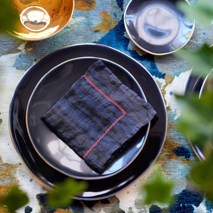 Assiettes et serviette de table bleu nuit et or, vus du dessus