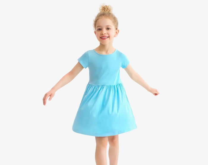 Child twirling wearing Primary Pocket Dress - Lagoon. Available at www.tenlittle.com