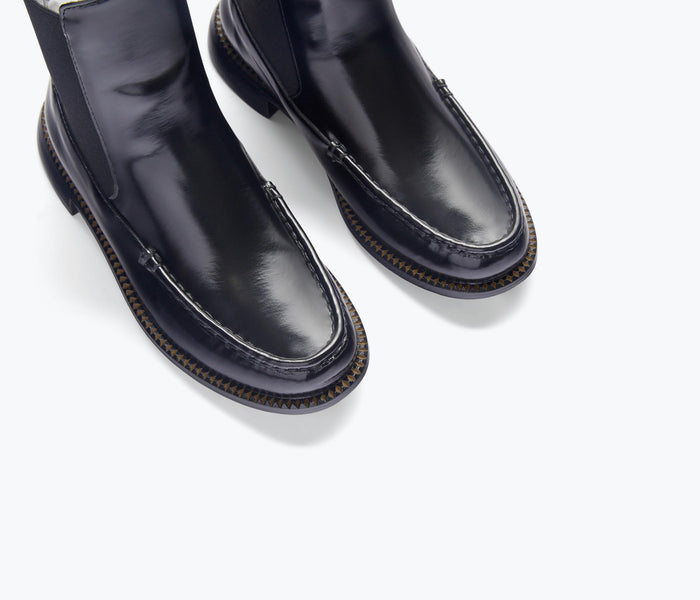 Black Renn moccasin Chelsea boot by Freda Salvador with sleek leather detailing and classic ankle-height design.