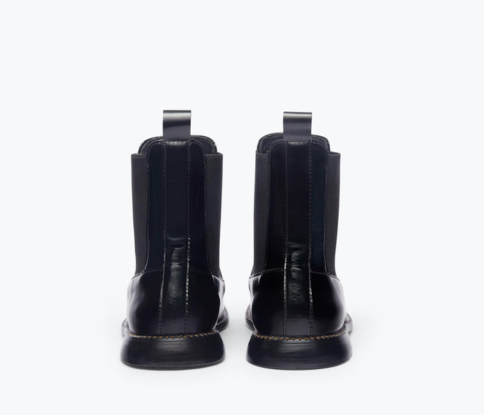 Black RENN moccasin Chelsea boot by Freda Salvador shown from the back, featuring sleek design and elastic side panels.