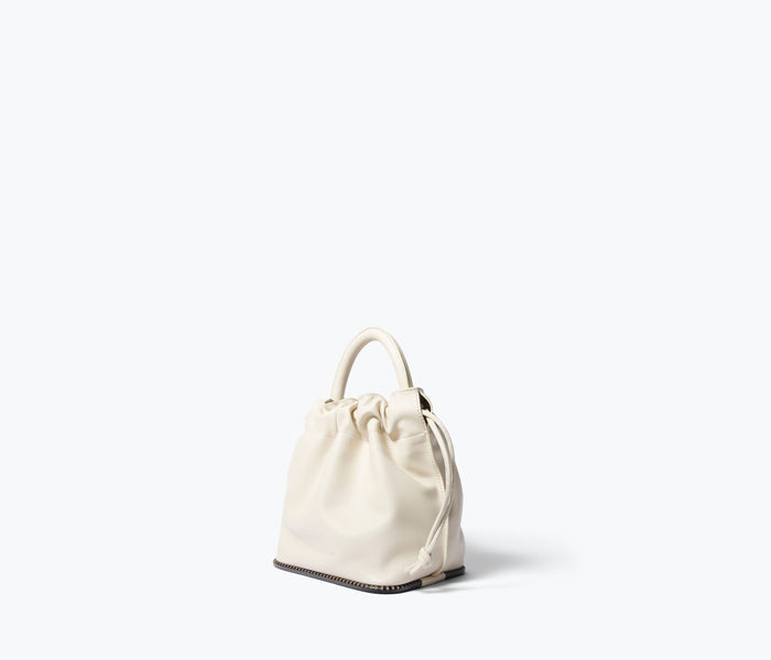 Freda Salvador Ruby bucket bag in bone calf leather, angled view showing its stylish design and compact size.