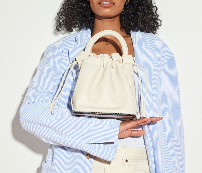 Freda Salvador Ruby Bucket Bag in bone color, stylish leather bag with sleek design and adjustable strap.