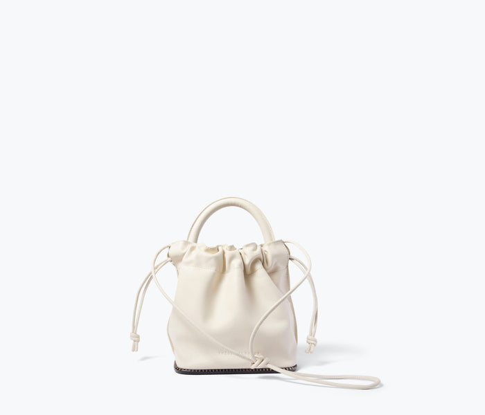 Freda Salvador Ruby bucket bag in bone calf leather, showing front view with straps and stylish design.
