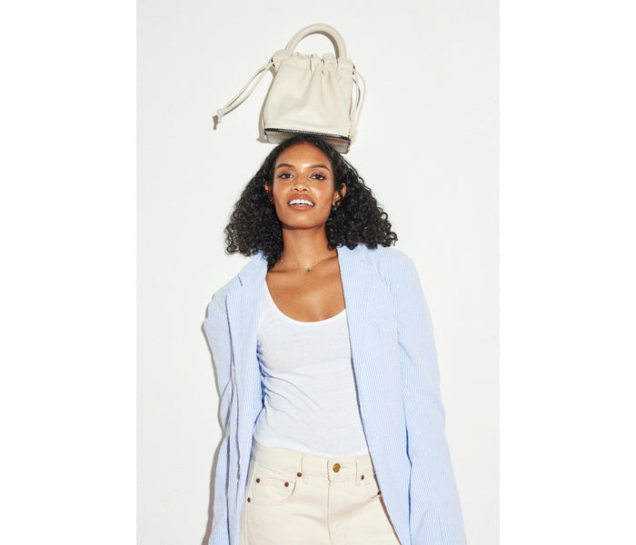 Freda Salvador Ruby Bone Bucket Bag with sleek design and gold hardware, stylish accessory for everyday use.