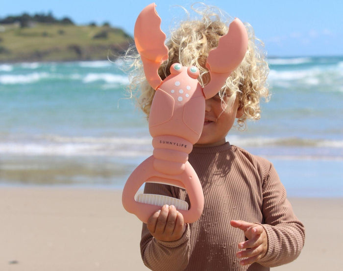 Child holding Sunnylife Sand Claw - Lobster. Available at www.tenlittle.com