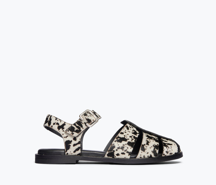 Freda Salvador SERA fisherman sandal in black and white cow print, front view showing stylish strap details and craftsmanship.