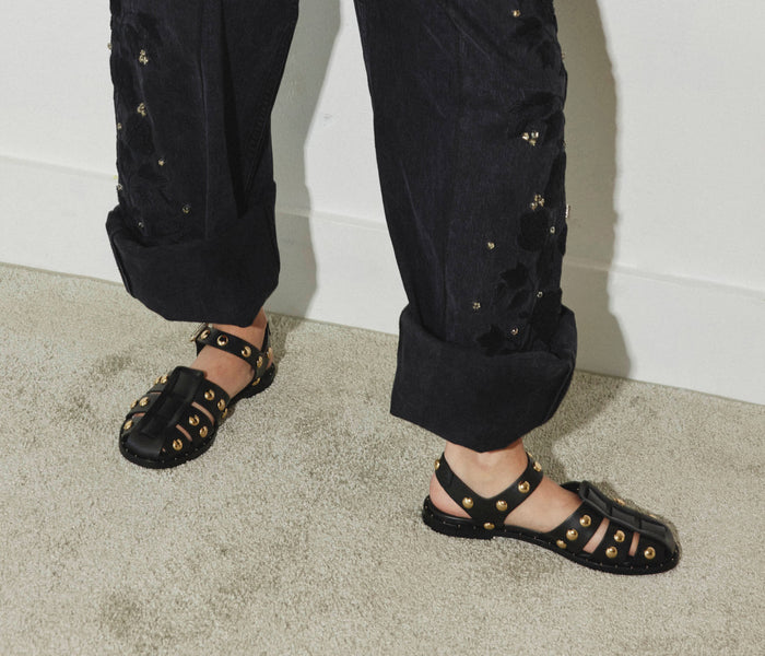 Freda Salvador Sera Fisherman Sandal in black with gold accents, featuring a strappy design and chunky heel.