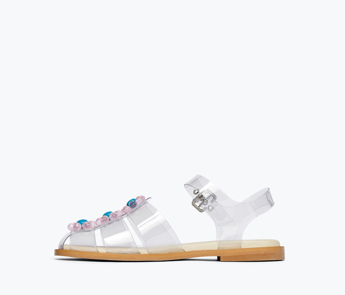 Clear PVC SERA Fisherman Sandal by Freda Salvador with flower embellishments, showcasing a stylish and transparent design.