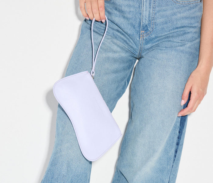 Lavender pebble leather Serena Slip Pouch by Freda Salvador, compact bag with sleek design and subtle branding.