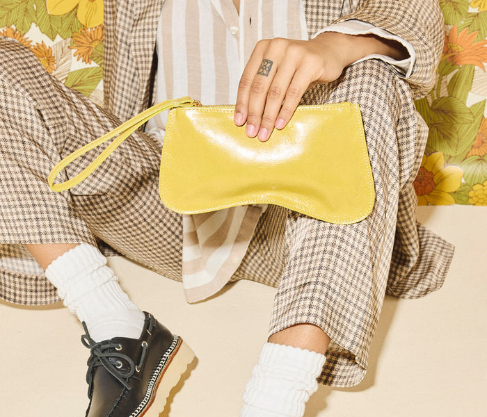 FREDA SALVADOR Serena Slip Pouch in mustard crinkle leather, compact bag with zip closure and sleek design.