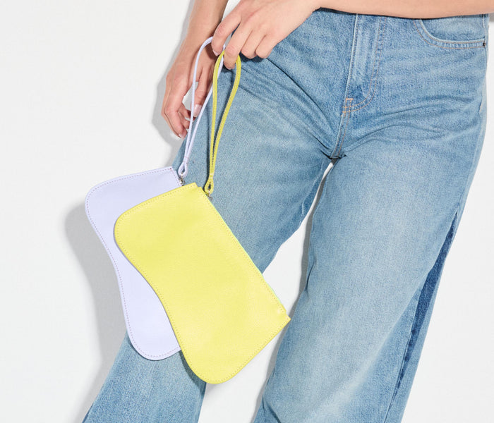 Charcoal-colored FREDA SALVADOR Serena slip pouch with pebbled leather texture, compact bag designed for cards and small essentials.