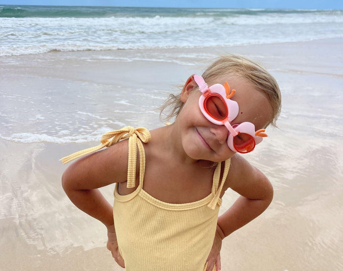 Girl at beach wearing Sunnylife Swim Goggles - Cherry. Available at www.tenlittle.com
