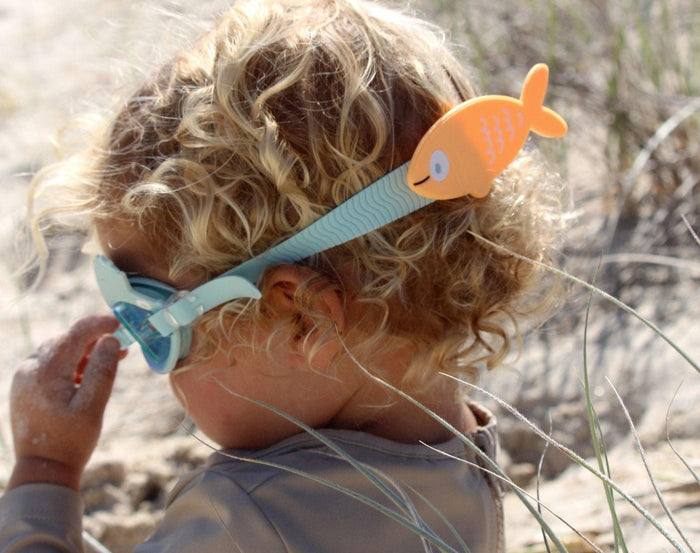 Child at beach wearing Sunnylife Swim Goggles - Fish. Available at www.tenlittle.com