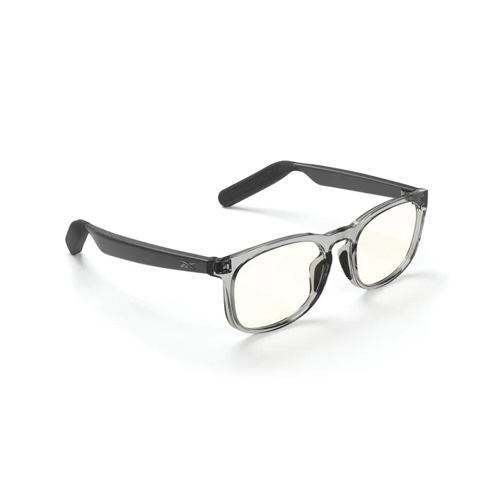 The Reebok Thunder smart glasses feature translucent gray rectangular frames, black arms, and slightly yellow-tinted lenses—designed for privacy-focused users seeking style and innovation. Displayed on a white background.