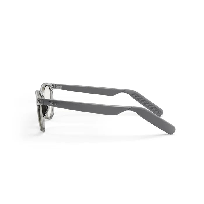 The Reebok Thunder smart eyewear features clear round frames and straight gray arms with slightly curved ends, shown from the side against a white background.