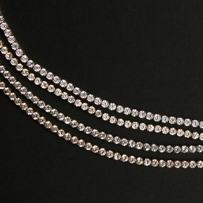 Three strands of white sapphire tennis bracelets on a black background