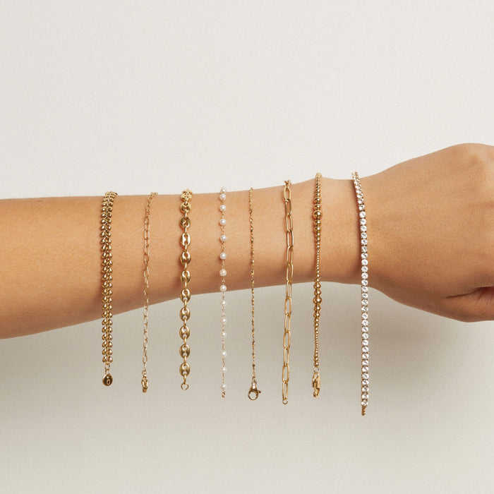 Model. Multiple bracelets on a wrist against a neutral background
