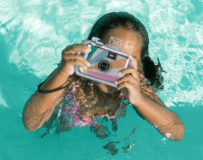 Child in pool taking a photo with Sunnylife Underwater Camera - Pastel. Available at www.tenlittle.com