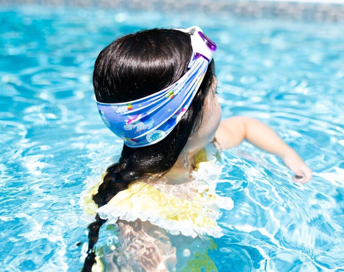 Child in pool with Splash Place Unicorn Tangle-Free Swim Goggles. Available from www.tenlittle.com