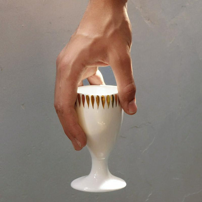 mazagran en porcelaine blanche et or tenu par une main - tsé tsé