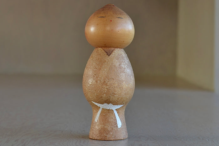An artisan Kokeshi dolls called Muchin (Innocense) in small. These depict a child with a boyish look. Handmade in Japan by Misao Watanabe (1917-2007), possibly the most popular Sosaku artisans. He won the Prime Minister's Prize in 1963 and 1981.