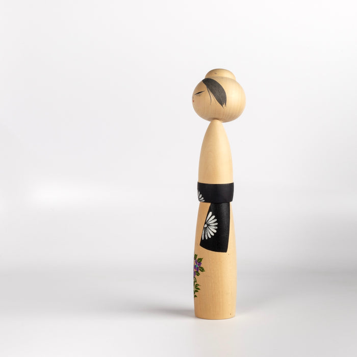 Side view of floral kokeshi by  Sato Suigai (1920-).