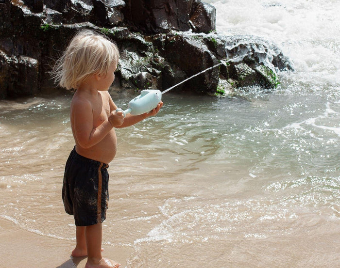 Child at beach spraying Sunnylife Water Soaker - Shark. Available at www.tenlittle.com