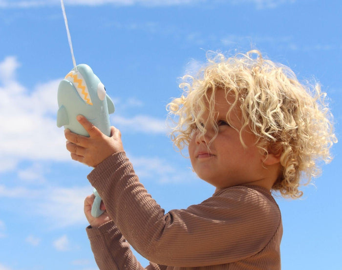 Child spraying Sunnylife Water Soaker - Shark. Available at www.tenlittle.com