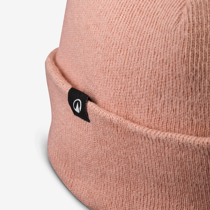 Close-up of a pink beanie with a brand logo on a white background