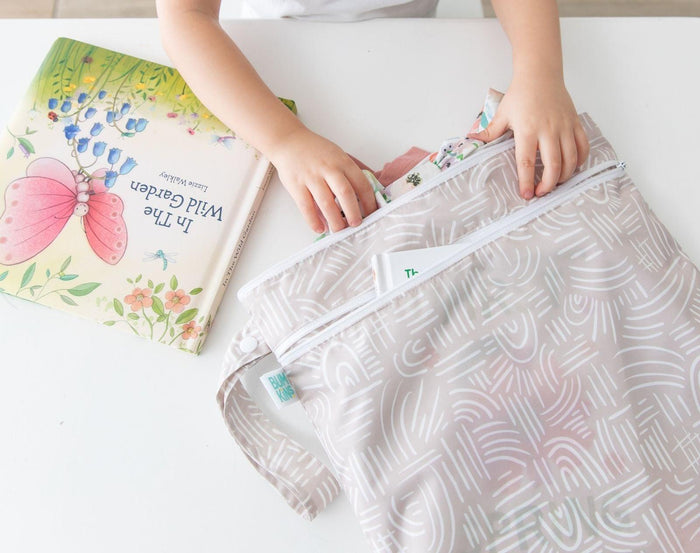Child utilizing the Bumkins Wet/Dry Bag - Wander. Available from www.tenlittle.com