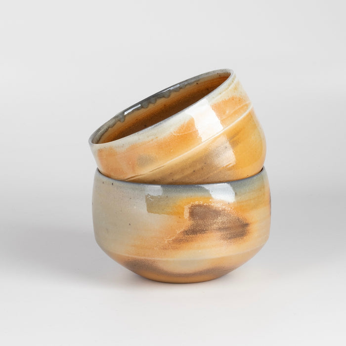 Two hand thrown and wood fired porcelain bowls by Lilith Rockett.